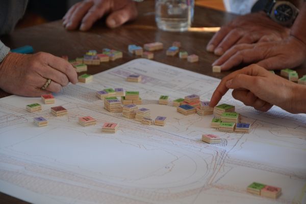 Holzblöcke werden auf einem Lageplan von Workshopteilnehmenden verrückt